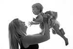 Mama hebt Baby hoch auf dem Armen